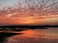 A picturesque sunset over a tranquil lake.