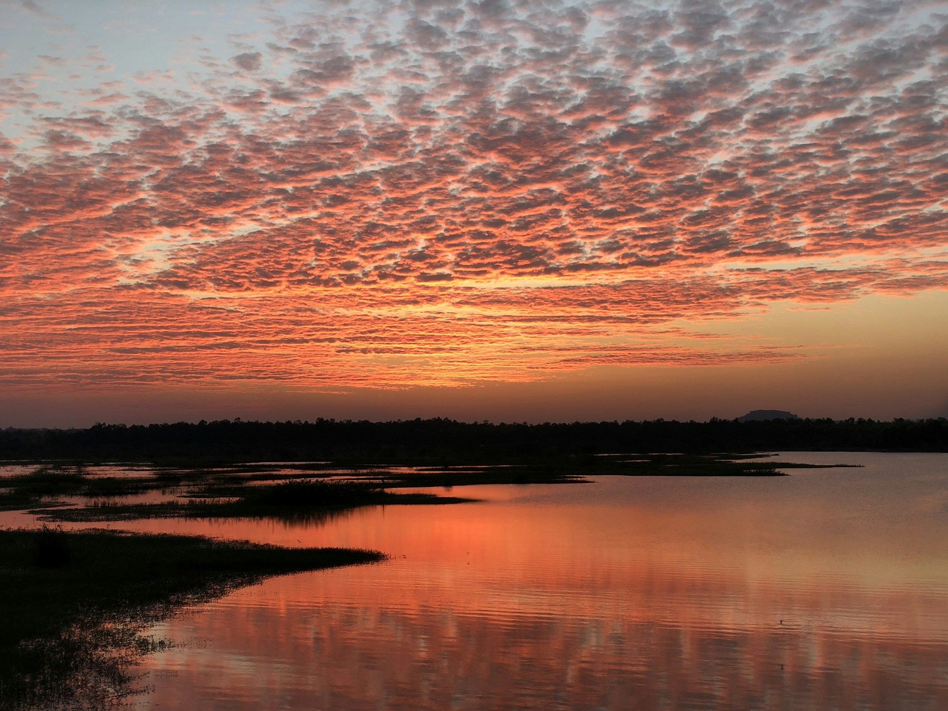 A breathtaking landscape showcasing a vibrant sunset over a serene lake, reflecting the warm hues of the sky.