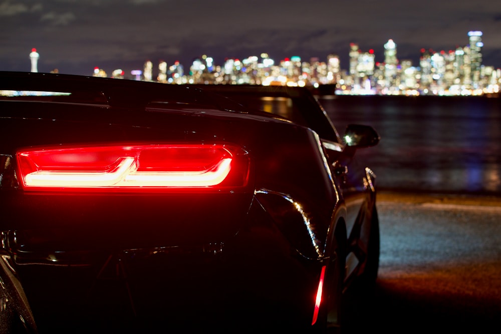 black convertible coupe near shoreline