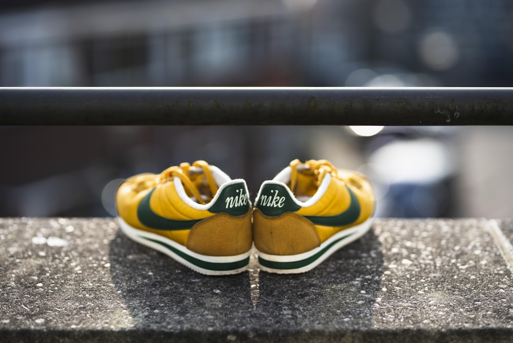 fotografia de foco seletivo de sapatos Nike Cortez amarelo-preto-e-branco