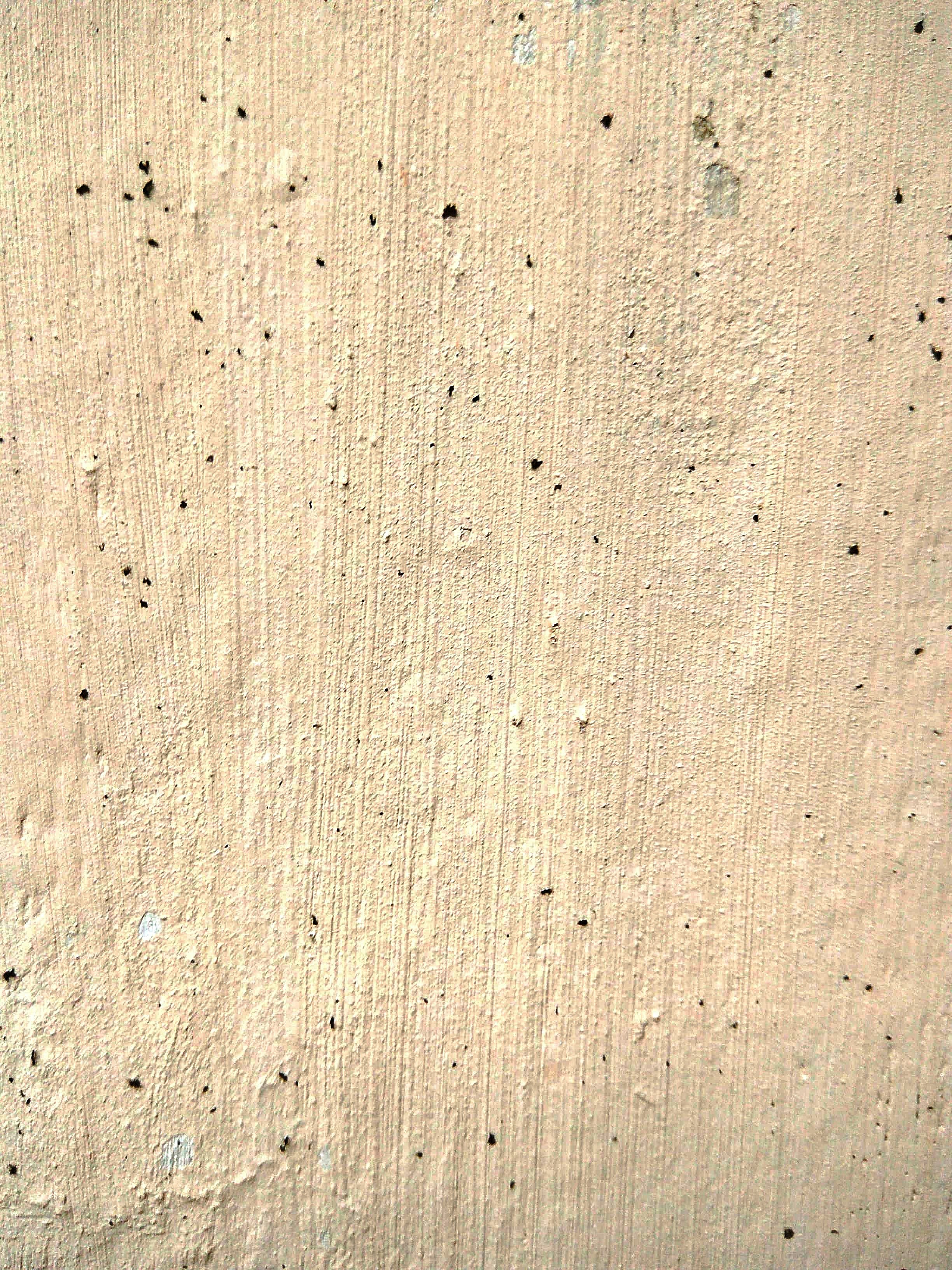 a red fire hydrant sitting on the side of a cement wall