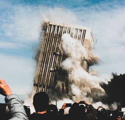 people taking photo of collapsing building