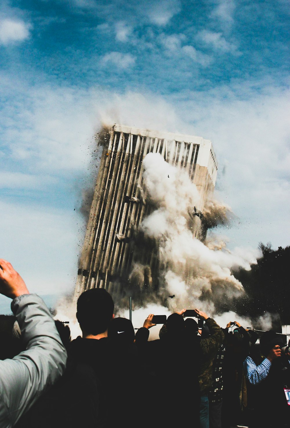 Gente tomando foto de edificio que se derrumba