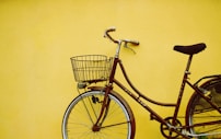 female beach cruiser bike leaning on yellow painted wall