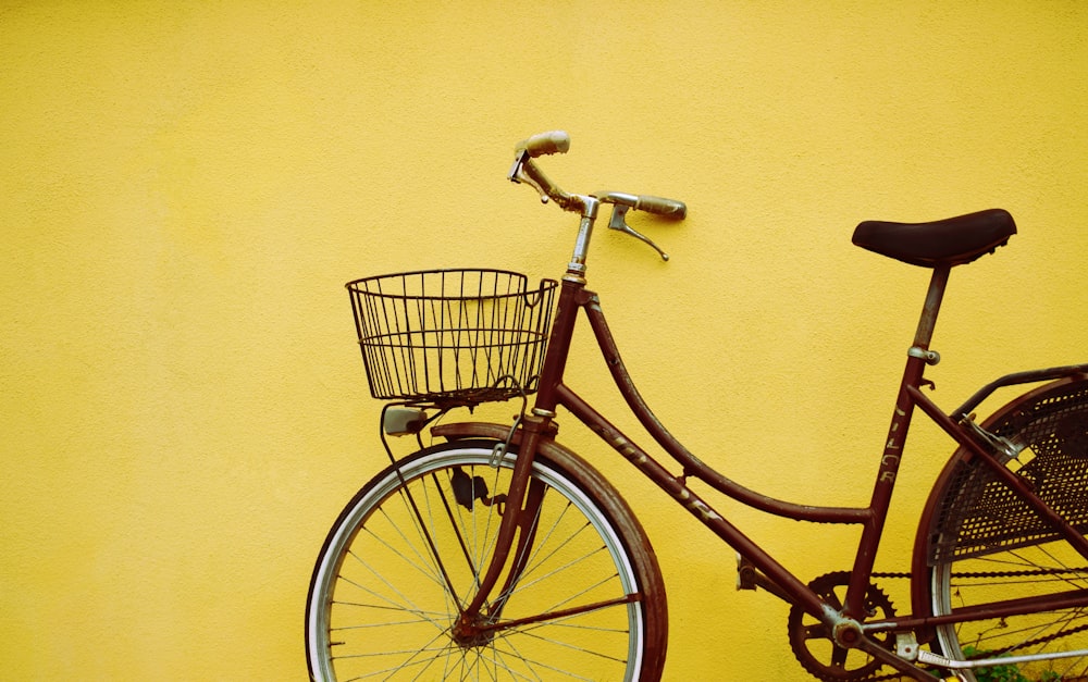 여성 해변 순양함 자전거 노란색 페인트 벽에 기대어
