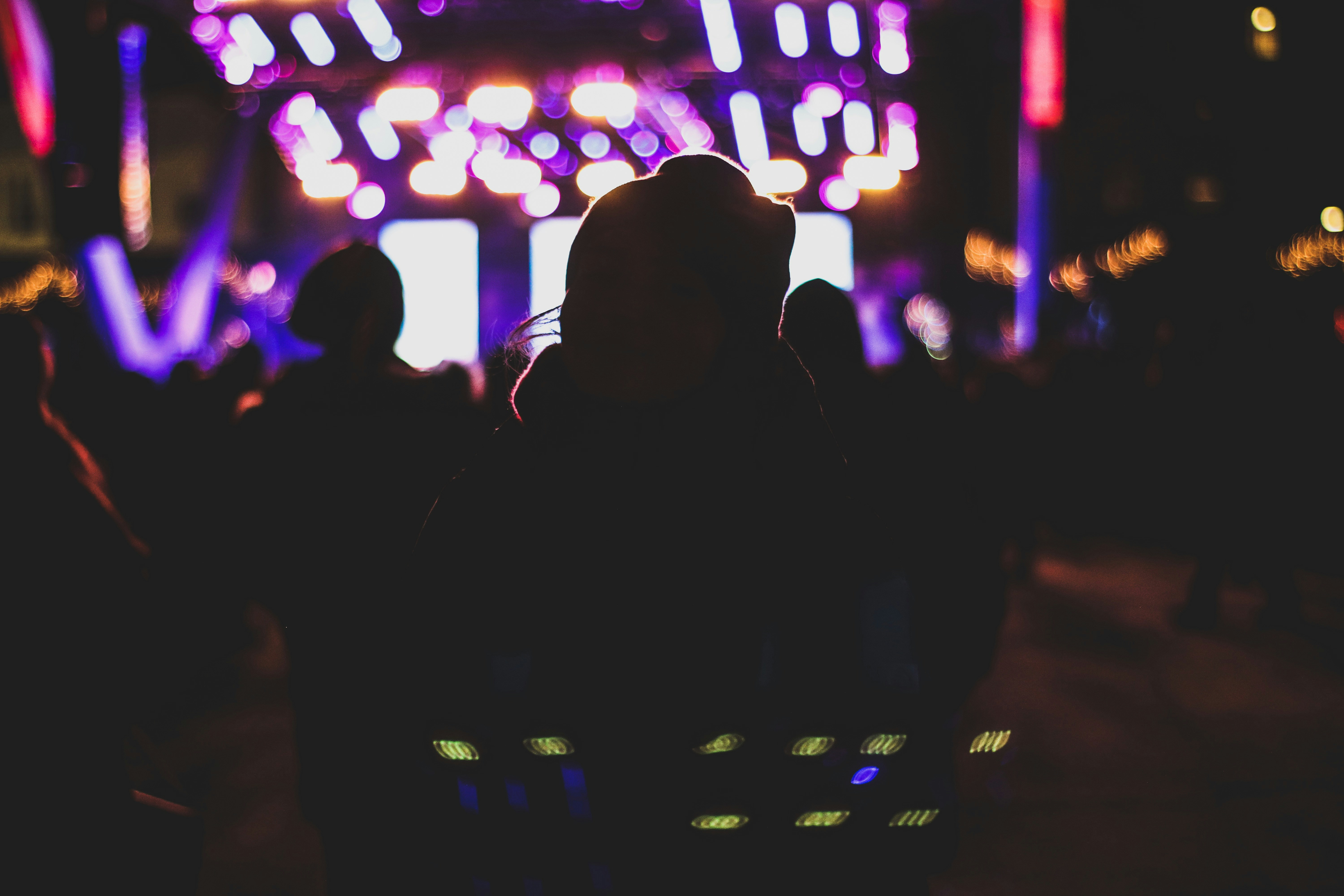 Concert stage with dramatic purple and white lighting and crowd silhouettes