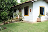 white concrete house beside green leafed trees