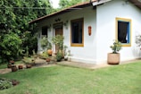 white concrete house beside green leafed trees