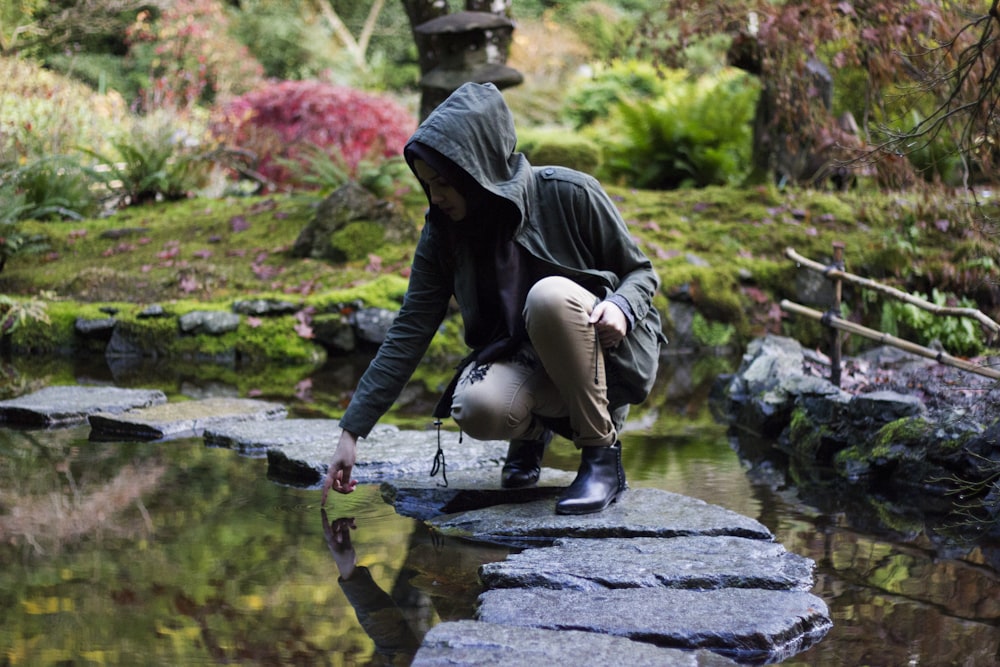 person touching body of water