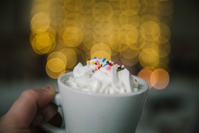 A festive seasonal bomb with colorful sprinkles melting in a warm drink on a cozy table.
