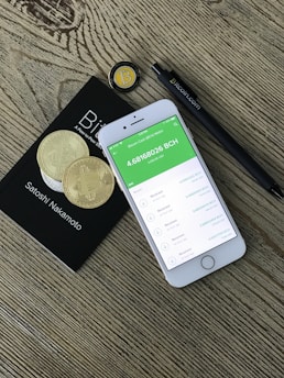 silver iPhone 6 beside two coins