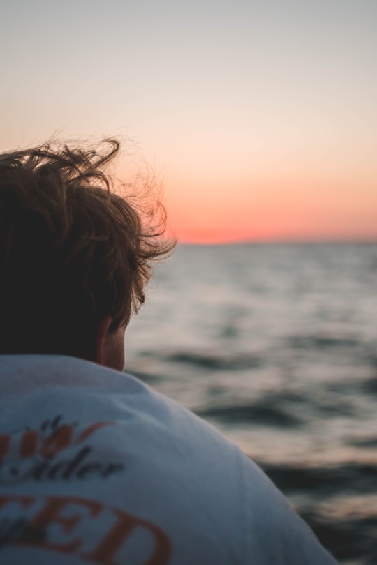 man sitting near body of water during golden hour in Fraser Island Australia