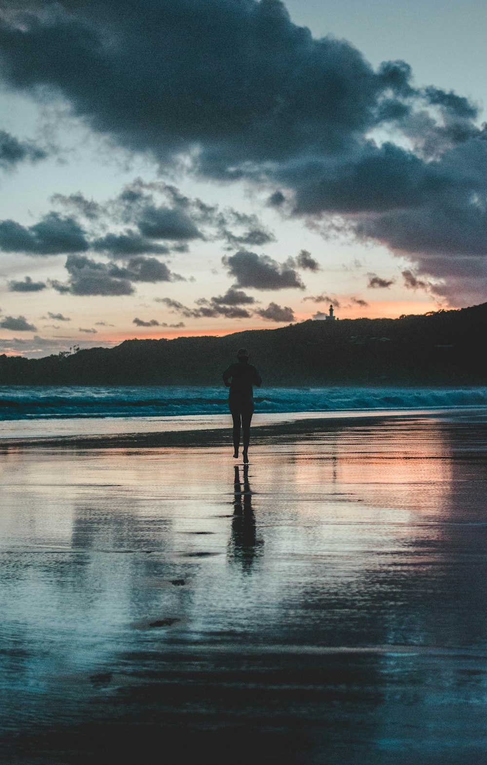 person walking on seashore