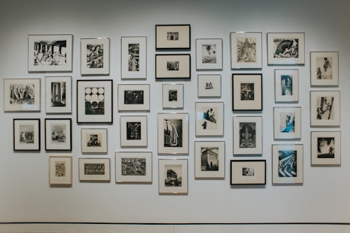 A gallery wall featuring various modern photo frames in black and white tones.