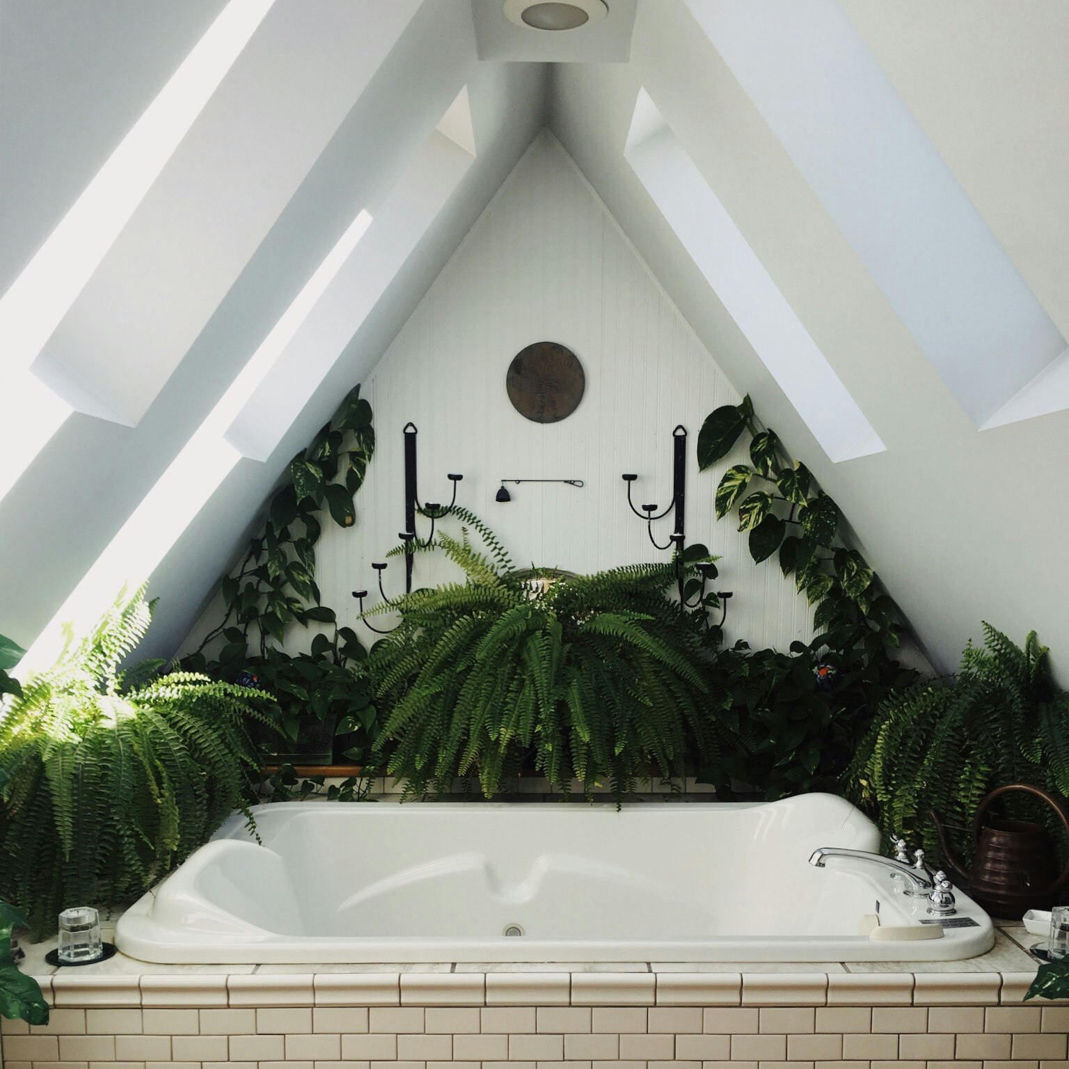 white bathtub surrounded with flowers