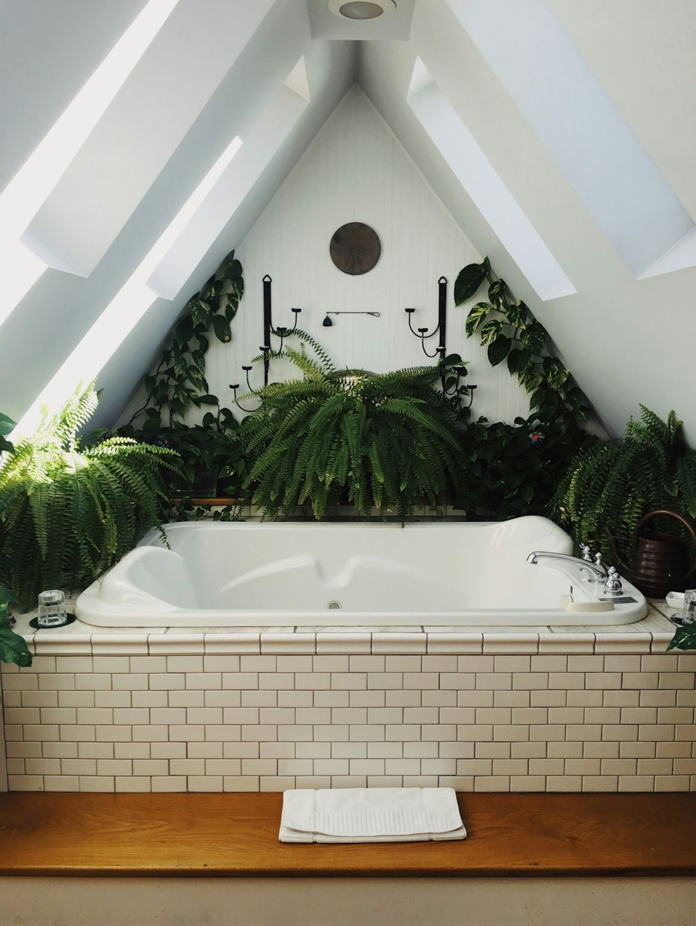 white bathtub surrounded with flowers