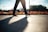 A person walking on a sunny path wearing stylish sports shoes.