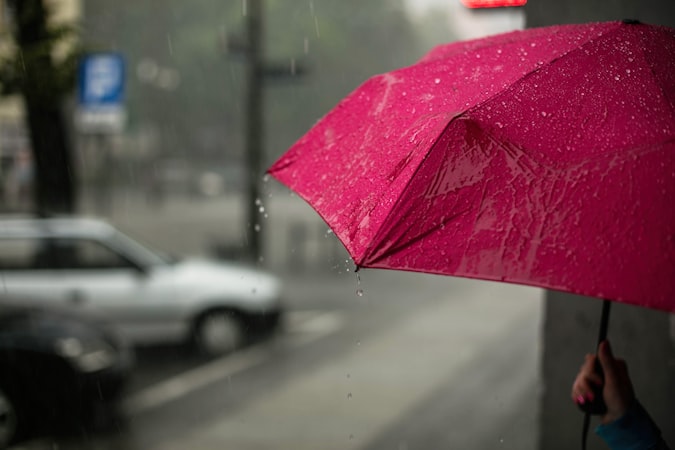 Colourful umbrellas seen from below against a grey sky