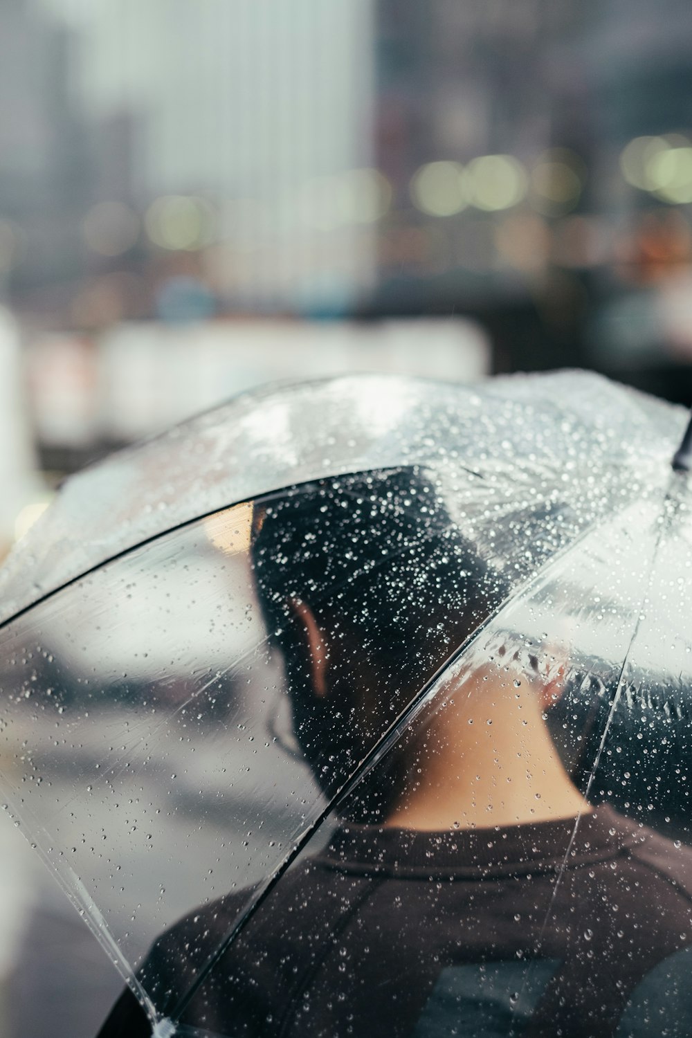 selective focus photography of person under transparent umbrella