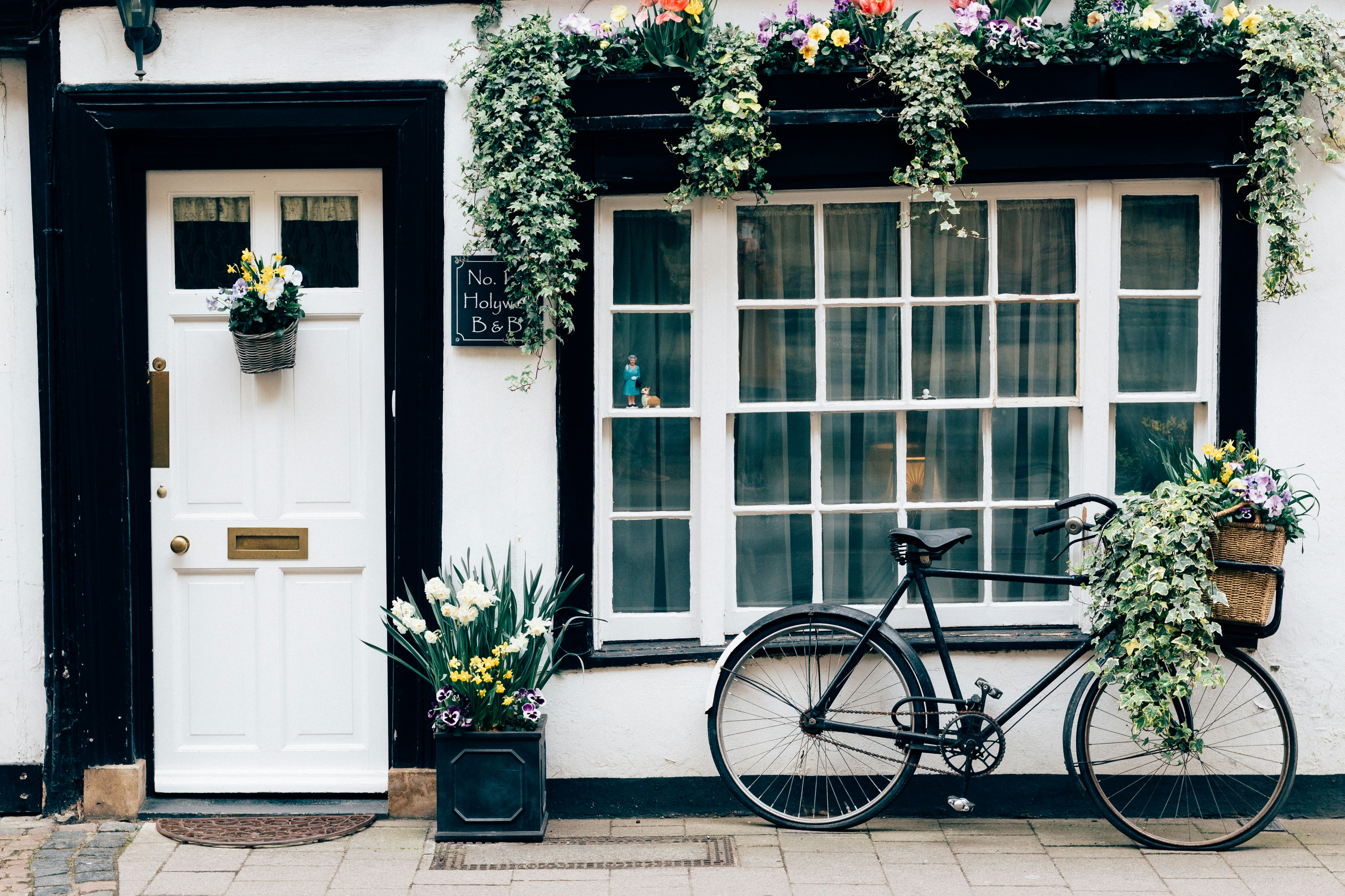 black fixie bike near white wooden door