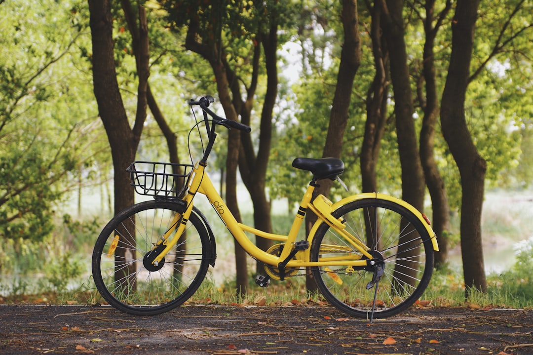 yellow commuter bike parked near trees
