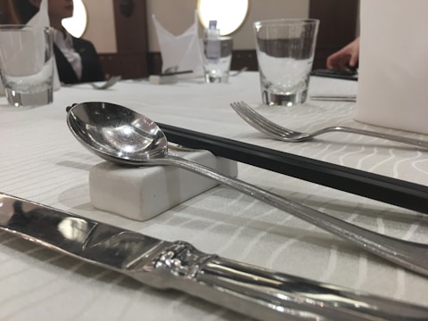 Elegant table setting featuring stainless steel knives and spoons.