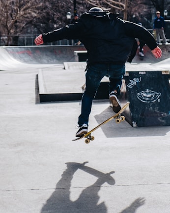 A rider performing a trick on a concrete skatepark ramp.
