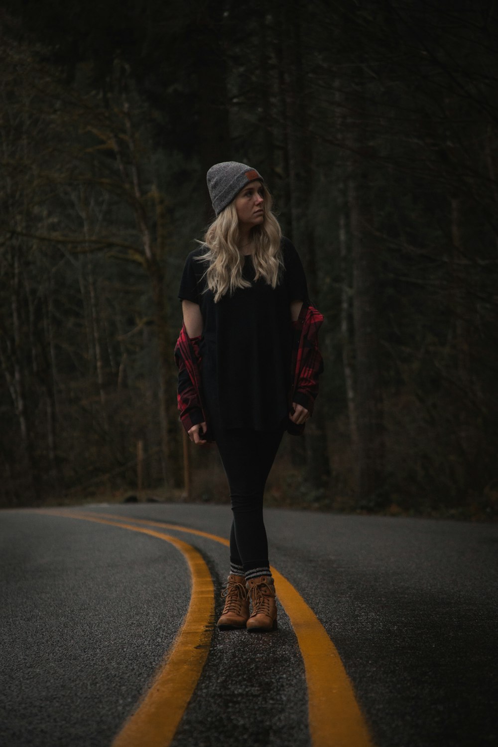 woman standing on road near trees