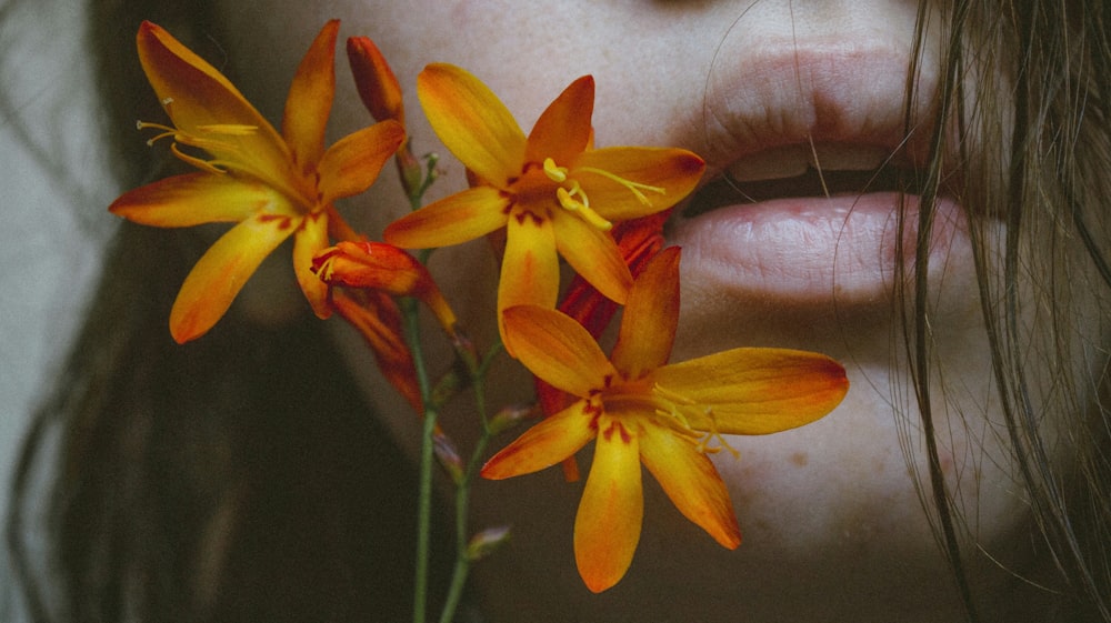 woman's face near orange petaled flowers