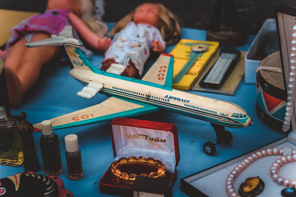 closeup photo of airplane scale model and jewelry