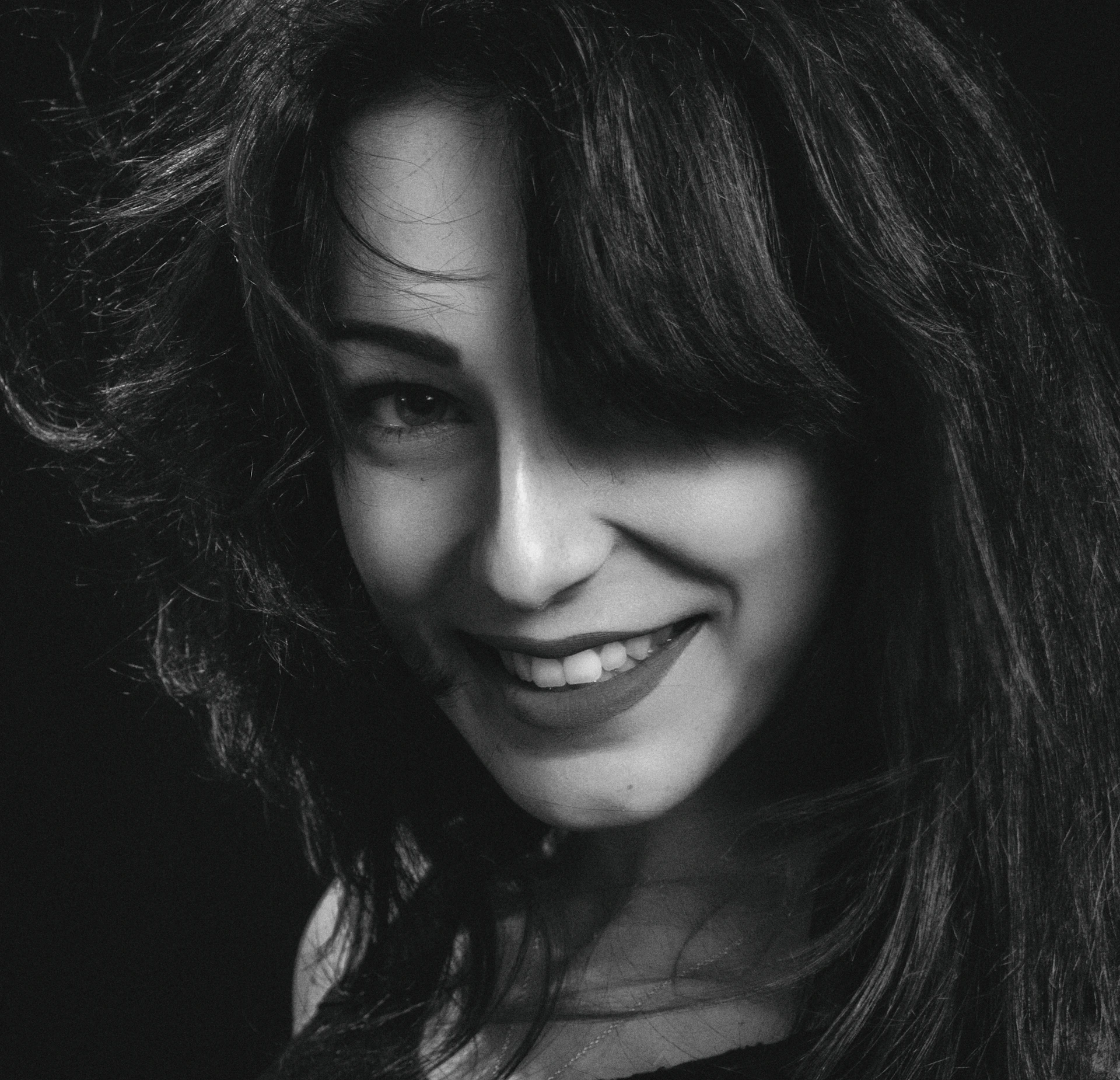 A before-and-after portrait showcasing a stunning hair transformation with glossy, perfectly styled locks against a minimalist black backdrop.