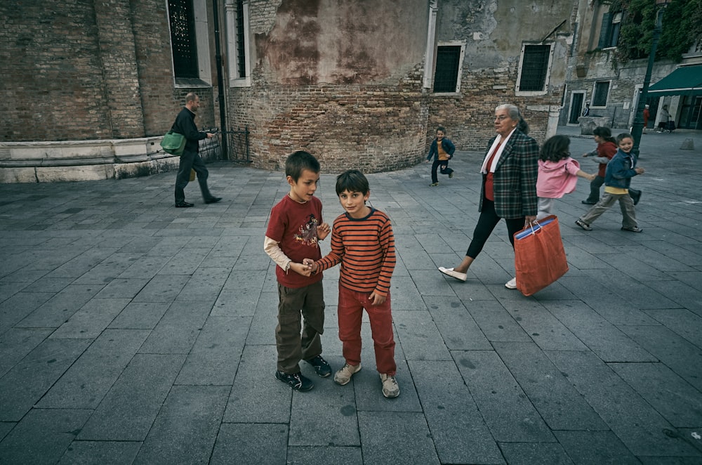 two boys standing in-front building