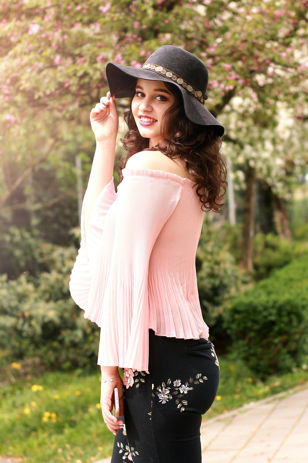 woman wearing black sun hat surrounded by trees