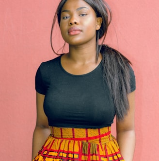 woman wearing black shirt standing in front of red wall