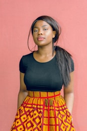 woman wearing black shirt standing in front of red wall