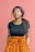 woman wearing black shirt standing in front of red wall