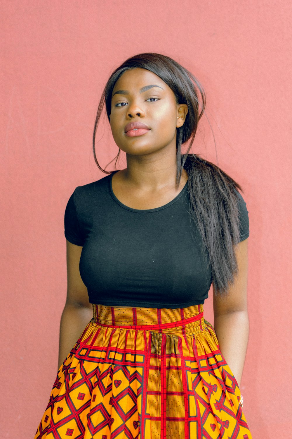 woman wearing black shirt standing in front of red wall