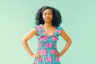 A plus-size Hispanic woman smiling confidently in a vibrant custom dress.