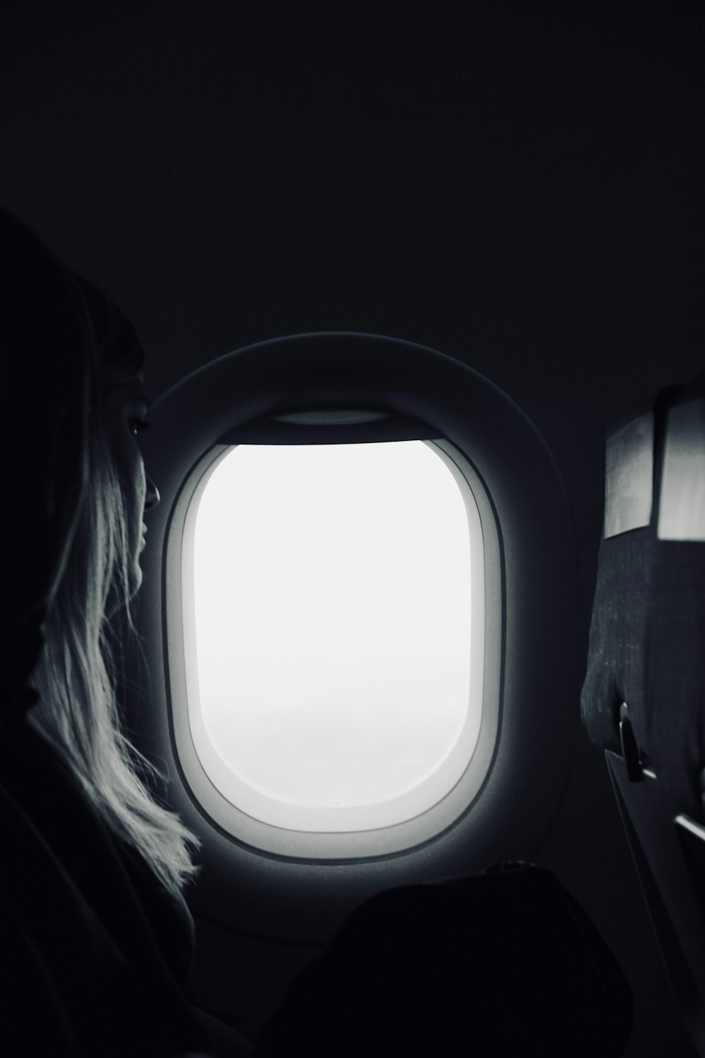 person sitting beside airplane window