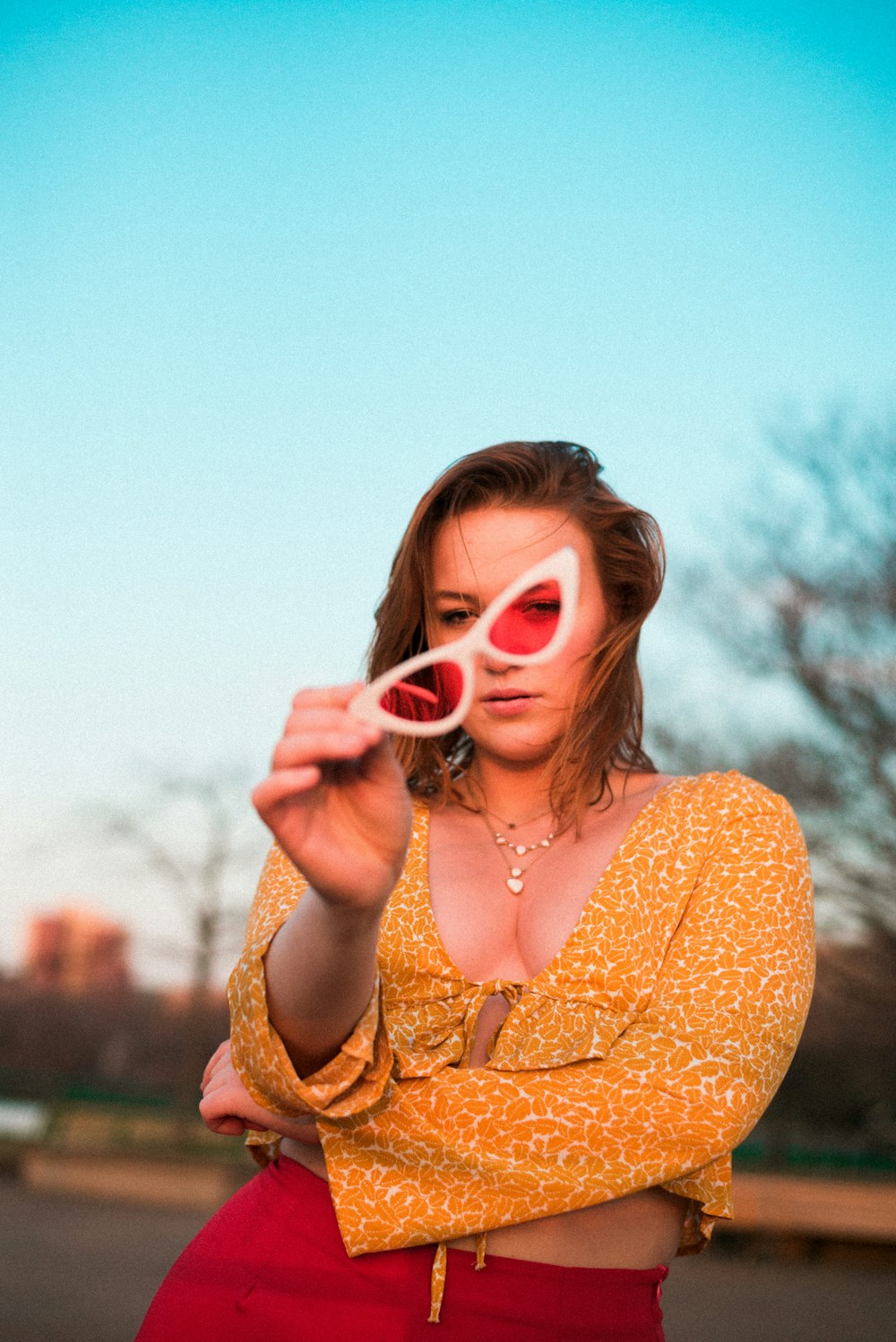 femme tenant des lunettes de soleil