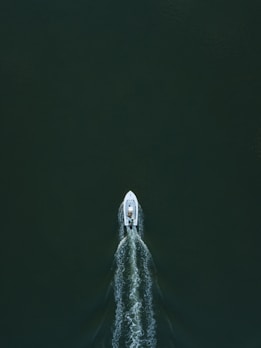 white powerboat at body of water leaving water trail