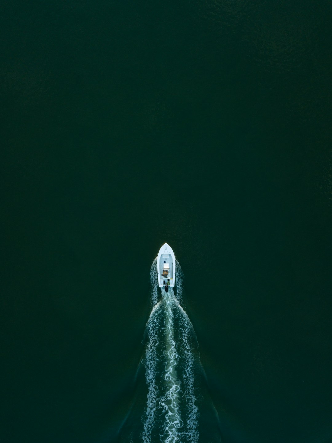 white powerboat at body of water leaving water trail