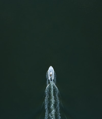 white powerboat at body of water leaving water trail