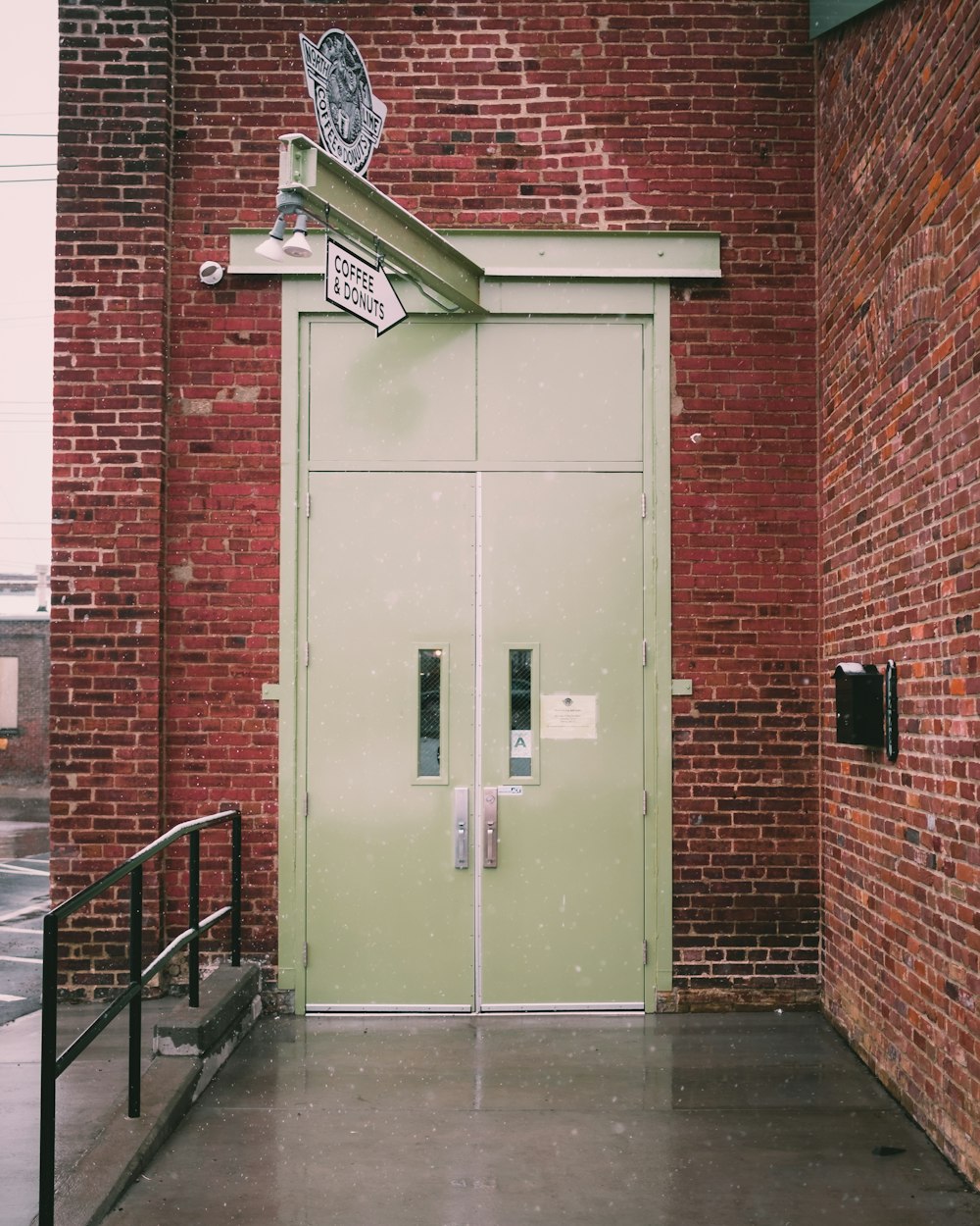 a building with a green door and a sign on it