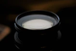 Close-up of a premium camera lens reflecting soft studio lights.