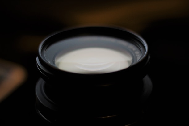 Close-up of a camera lens with soft natural light reflecting off it.