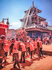 Volunteers building a temple with traditional tools and community spirit.