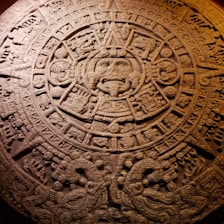 Ancient Aztec calendar stone carved with intricate symbols and glyphs.