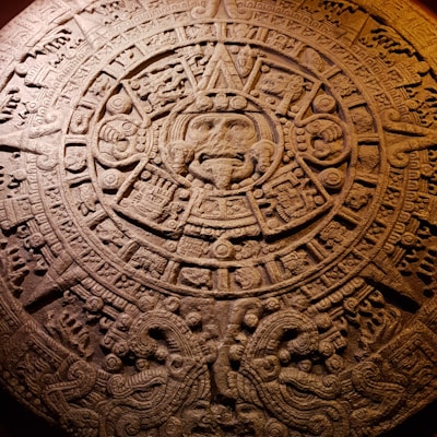 Ancient Aztec calendar stone carved with intricate symbols and glyphs.