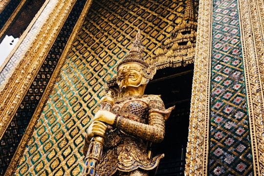person holding rod statue in Temple of the Emerald Buddha Thailand